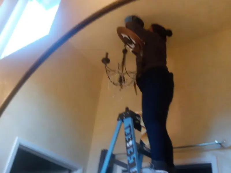 Electrician installing a chandelier in a Fremont residence